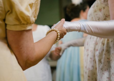 Closeup of people in period clothes holding hands