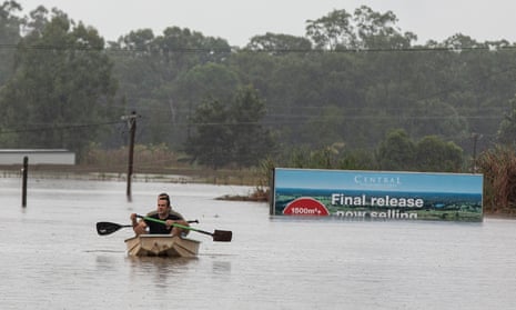 FLOODS: In a dingy borrowed from the neighbours, Shane Hughes rows in from checking on his mother house which is close to being flooded inside. Behind him sits a friend Michael Carn who is helping him out, Pitt Town, Sydney, 22 March 2021