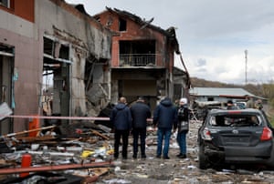 People look on at the destruction caused when a civilian building was hit by a Russian missile in Lviv.