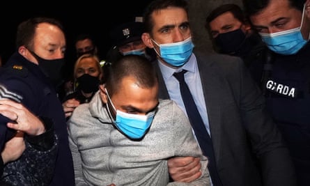 Jozef Puska is held by police as he is led into a police station