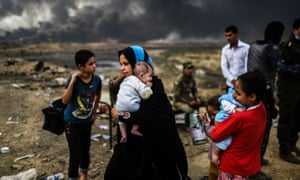 Iraqi families who were displaced by the ongoing operation against Islamic State in Mosul walk along a road near Qayyarah on Monday.