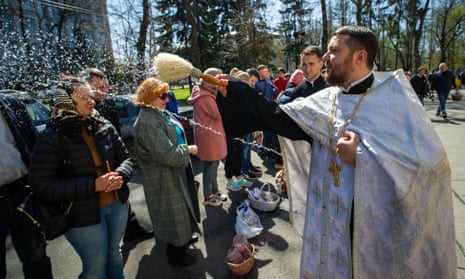 Ukrainian Father Oleksandr Shmurygin blesses parishioners and food with sprays of holy water at St Volodymyr’s Cathedral in central Kyiv.