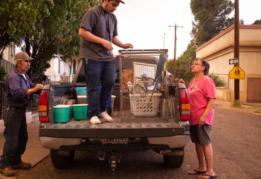 Ralph García, izquierda, Josiah Arvizu y Patsy Arvizu cargan su camión el lunes mientras evacuaban del incendio del Telegraph en Miami, Arizona.