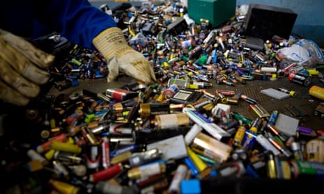 A waste operative sorts through piles of batteries