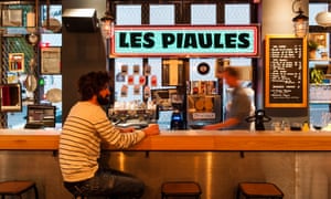 A man sits at the bar at Les Piaules hostel, Paris.