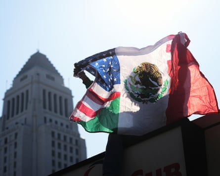 A person holds up an American and Mexican flag outside the Federal Building in LA.