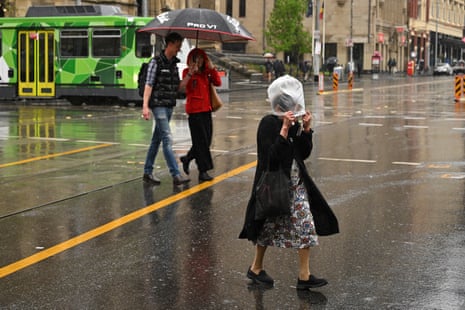 People crossing a street in the rain in Melbourne