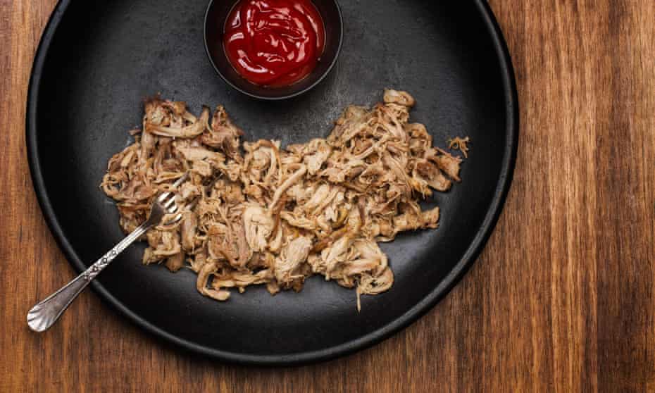 Pulled pork in a black plate on a wooden table2A4FFF8 Pulled pork in a black plate on a wooden table