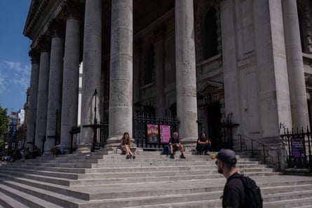 Several people sat on steps with columns behind