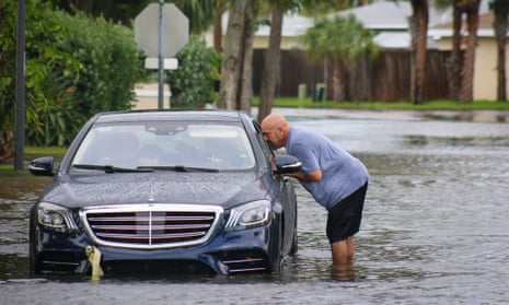Melvin Juarbe, right, tries to help an unidentified driver whose car stalled due to flooding from Hurricane Helen in Madeira Beach on Thursday, September 26, 2024.