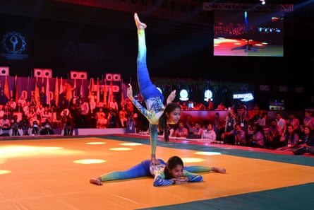 gymnasts balanced on a big mat in front of an audience