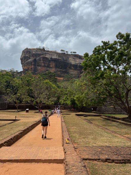 A woman walks towards the rocky fortress of Sigiriya in Sri Lanka