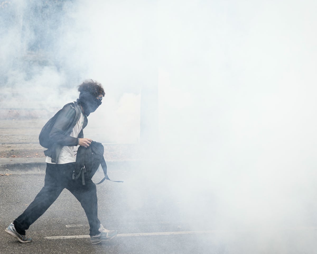 A student walks in a cloud of tear gas smoke as part of a student blockading protest near the Couffignal secondary school, in Strasbourg.