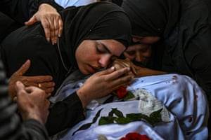 A woman mourns over the body of a man during his funeral