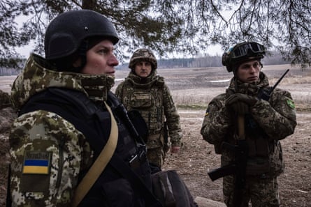 Lt. Col. Roman Tkach (left), Volodymyr Zhylchenko (center), and Artem Volynko (right) talk near a network of trenches just 1,500 meters from the Russian border.