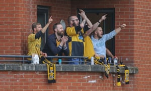 Cambridge fans watch their team's 4-2 win over Leyton Orient from a nearby apartment.