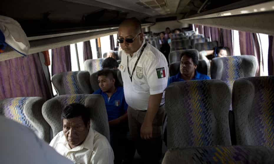 An immigration official checks a bus for Central American migrants at a roadblock north of Arriaga, Chiapas state, Mexico. 