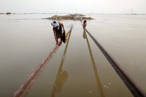 Villagers use part of a damaged railway track to cross floodwaters in Sultan Kot, Sindh province after torrential monsoon rains triggered Pakistan’s worst natural disaster on record in 2010
