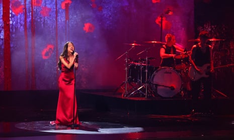 Olivia Rodrigo in a long red dress in concert
