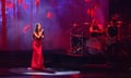 Olivia Rodrigo in a long red dress in concert