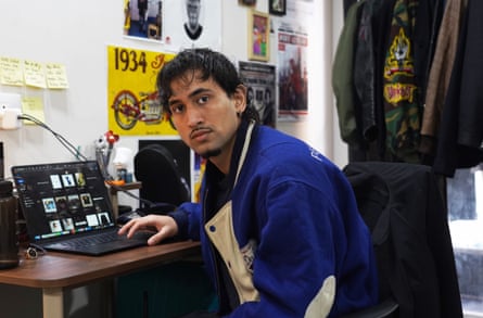 A young man sits at a laptop.
