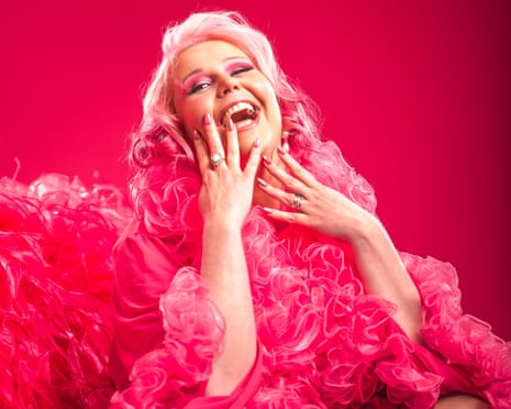 Comedian Lindsey Santoro wearing a pink frilled dress with pink hair, eyeshadow and nails