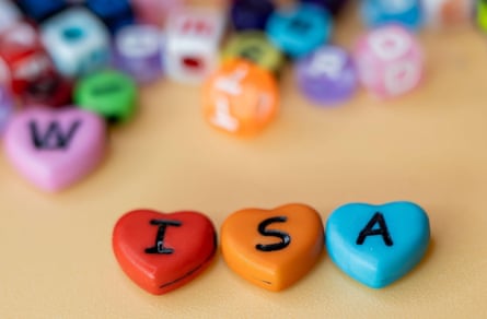 A pile of plastic hearts with letters on them, with three moved away to spell out Isa.
