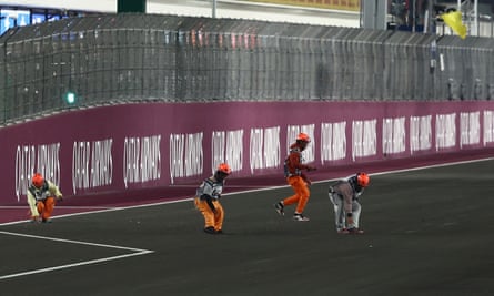 Marshals belatedly clear debris from the track.