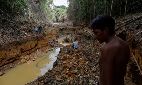 A Yanomami indian follows agents of Brazil’s environmental agency in a gold mine during an operation against illegal gold mining on indigenous land, in Roraima state, Brazil, in 2016.