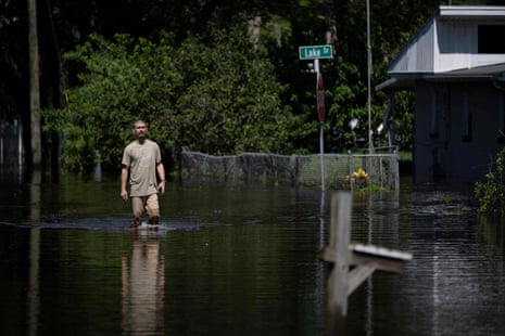 A man walks through a flooded street.