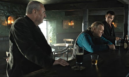 Jon Kenny at the bar of a pub with Brendan Gleeson and Colin Farrell in a scene from The Banshees of Inisherin.