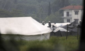 Riot policemen stand between tents inside the Idomeni camp on Tuesday morning.