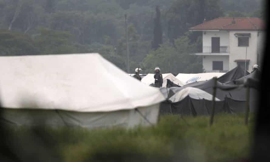 Riot policemen stand between tents inside the Idomeni camp on Tuesday morning.