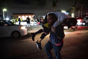A man carries an injured protester over his shoulder