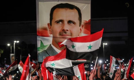 A portrait of Bashar al-Assad aid Syrian flags