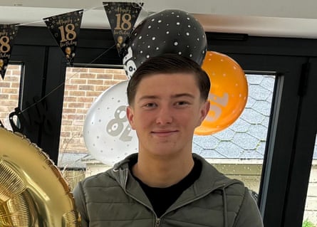 Henry Nowak with 18th birthday balloons and flags behind.