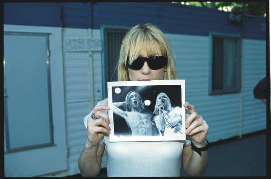 Kim Gordon holding an image of herself and Iggy Pop.