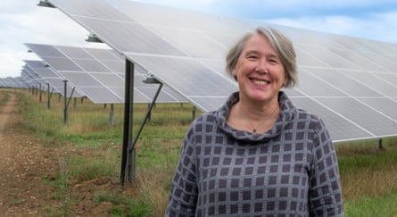 Barbara Hammond smiling in front of an array of solar panels in a field