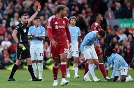 Ryan Gravenberch of Liverpool receives a red card from the referee Chris Kavanagh.