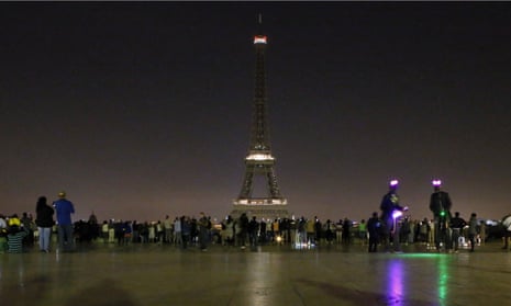 People gather at Trocadero plaza as the lights of the Eiffel tower falls dark at midnight in Paris, France, Wednesday May 24, 2017. Paris mayor Anne Hidalgo says the Eiffel Tower will fall dark overnight to honor the victims of the suicide attack at an Ariana Grande concert in Manchester that left 22 people dead as it ended on Monday night. (AP Photo/Francois Mori)