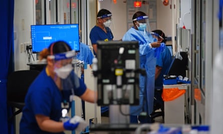 NHS medical staff wearing PPE work in a corridor in a ward for Covid patients.