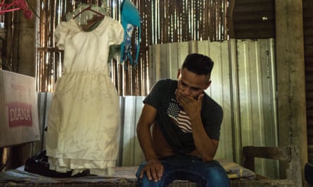 Arnovis Guidos Portillo breaks down after talking to his daughter on the phone. Her favourite dress hangs next to him.