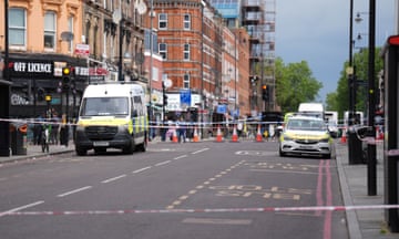police vehicles behind cordoned off section of road