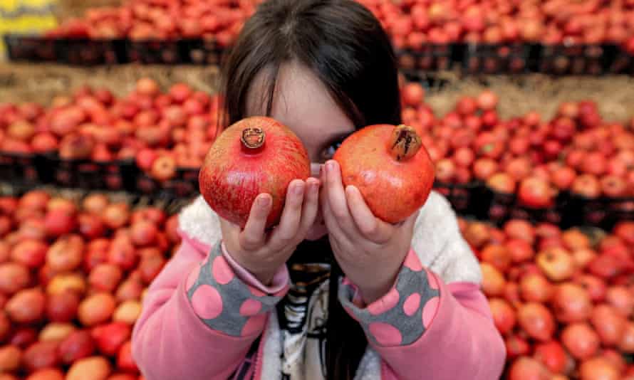 Girl holding two pomegranates