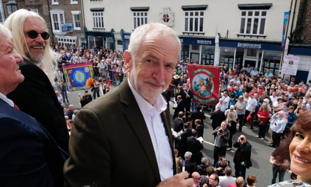 Labour leader Jeremy Corbyn stands on the balcony of the County Hotel as colliery bands play below during the 135th Durham Miners Gala on 13 July in Durham, England. 