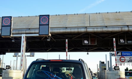 A car at a toll booth on a French highway.
