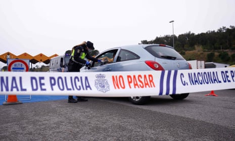 A Spanish police officer stops a car at the La Jonquera crossing between France and Spain