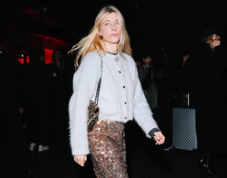 A guest fastens a brooch to the top of her cardigan outside the N21 show during Milan fashion week in February.