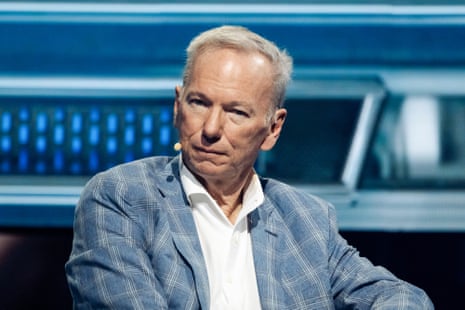 a man looks ahead while wearing a headset microphone