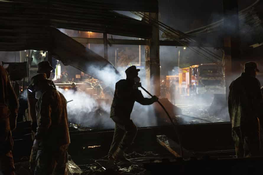 Volunteers and State Emergency Service firefighters work to extinguish a fire at a shopping center burned after a rocket attack in Kremenchuk, Ukraine, early Tuesday.